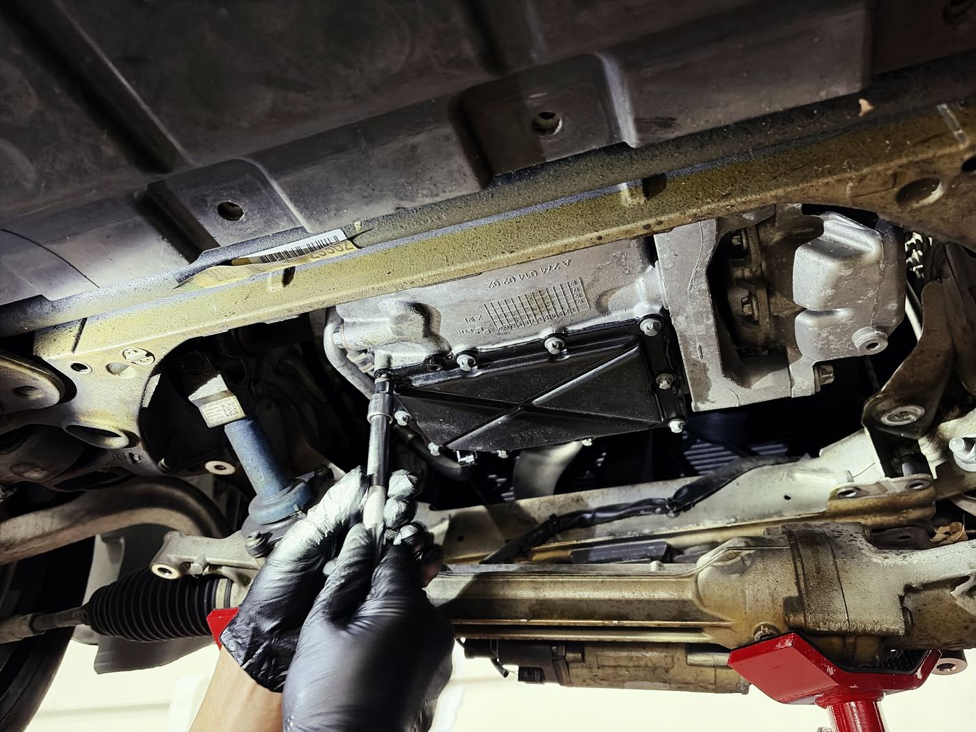 Mercedes M274 engine oil pan dropped on a lift, exposing the variable oil pump control valve housing