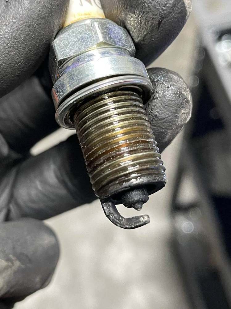Oil-fouled spark plug removed from Audi Q7 showing oil contamination