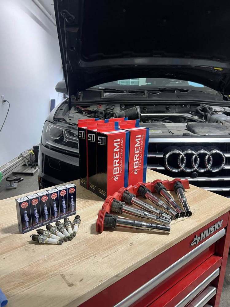 New spark plugs and ignition coils ready for installation on Audi Q7